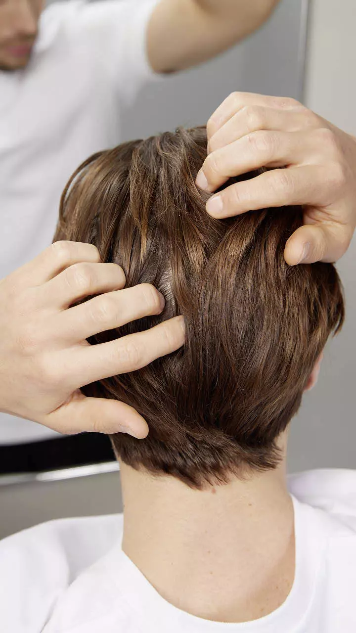 Ein Mann ertastet mit seinen Händen sein schütteres Haar am Hinterkopf und symbolisiert damit die Frage, was Männern mit Haarausfall helfen kann