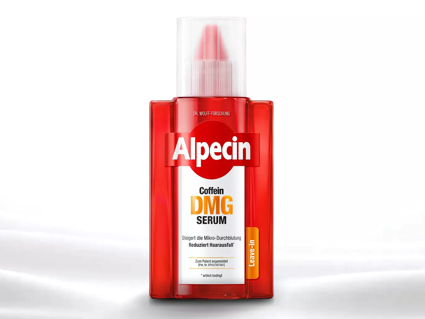 Eine rote Flasche Haarserum mit der Aufschrift "Alpecin Coffein DMG Serum" steht auf einer glatten, weißen Oberfläche.