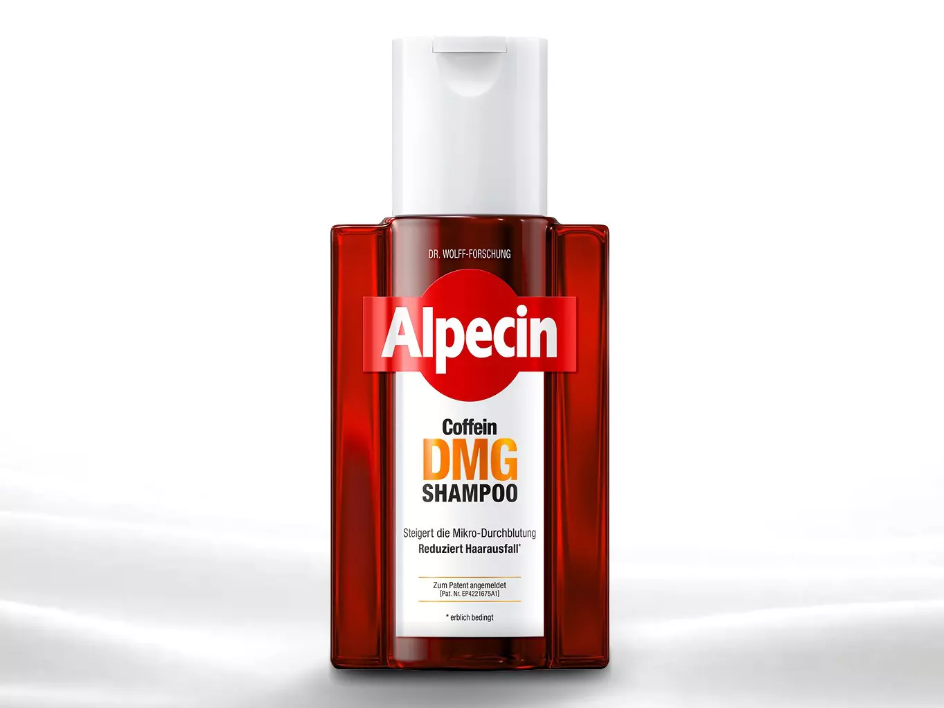 Eine rote Shampooflasche mit der Aufschrift "Alpecin Caffeine DMG Wirkkomplex" steht auf einer glatten, weißen Oberfläche.