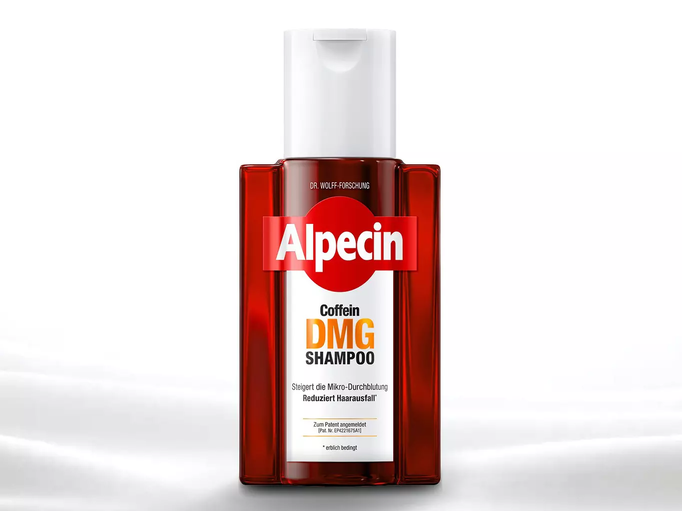 Eine rote Shampooflasche mit der Aufschrift "Alpecin Caffeine DMG Wirkkomplex" steht auf einer glatten, weißen Oberfläche.
